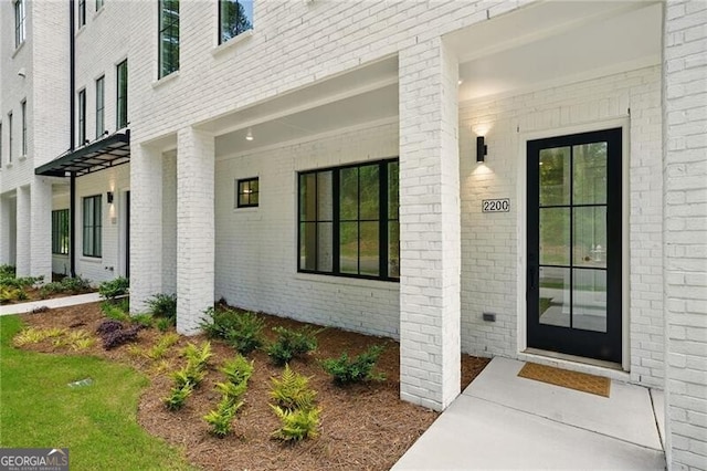 view of exterior entry with brick siding