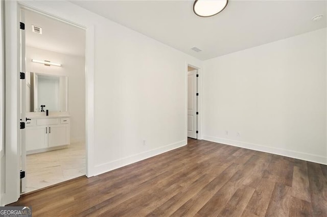 unfurnished room with wood finished floors and baseboards