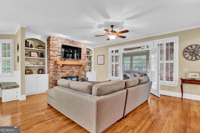 living room with light wood-style flooring, ceiling fan, ornamental molding, plenty of natural light, and built in features