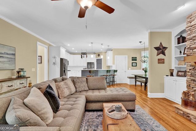 living room featuring ceiling fan, ornamental molding, light wood-style flooring, built in shelves, and recessed lighting