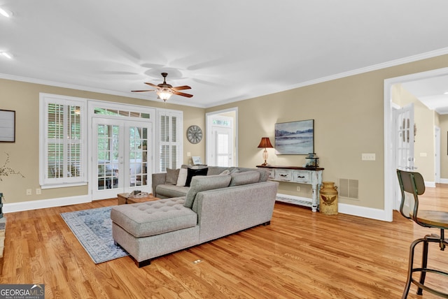 living room with french doors, a ceiling fan, light wood-type flooring, crown molding, and baseboards