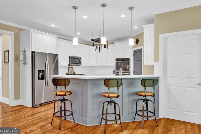 kitchen with appliances with stainless steel finishes, a kitchen bar, decorative backsplash, white cabinets, and crown molding