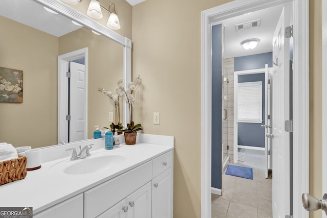 full bathroom with tile patterned flooring, vanity, a shower stall, and baseboards
