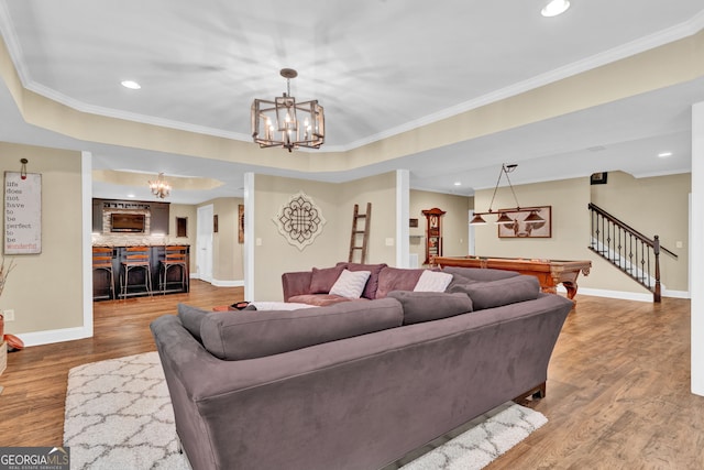 living area featuring a chandelier, wood finished floors, baseboards, recessed lighting, and crown molding