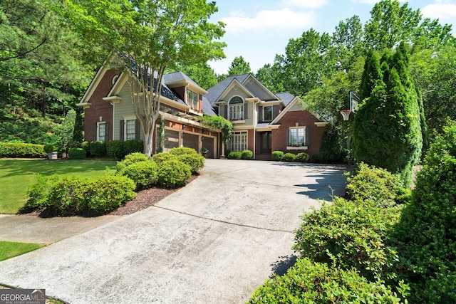 view of front of house with driveway, an attached garage, brick siding, and a front lawn