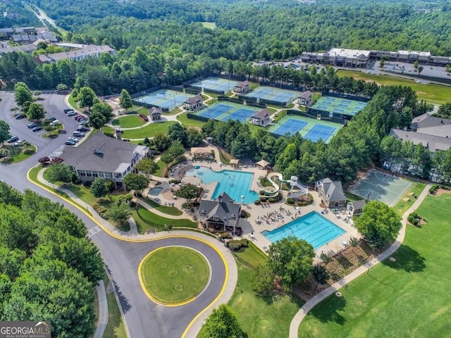 view of property location featuring a pool and a heavily wooded area
