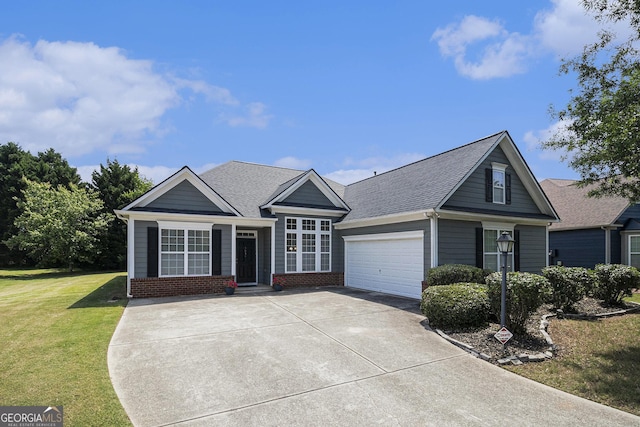 view of front facade with driveway, a front yard, brick siding, a garage, and roof with shingles