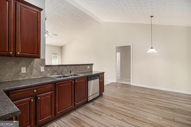 kitchen featuring stainless steel dishwasher, dark countertops, light wood-style floors, tasteful backsplash, and a sink