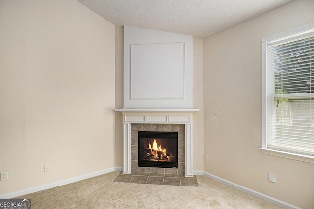 detailed view of a fireplace, carpet flooring, and baseboards