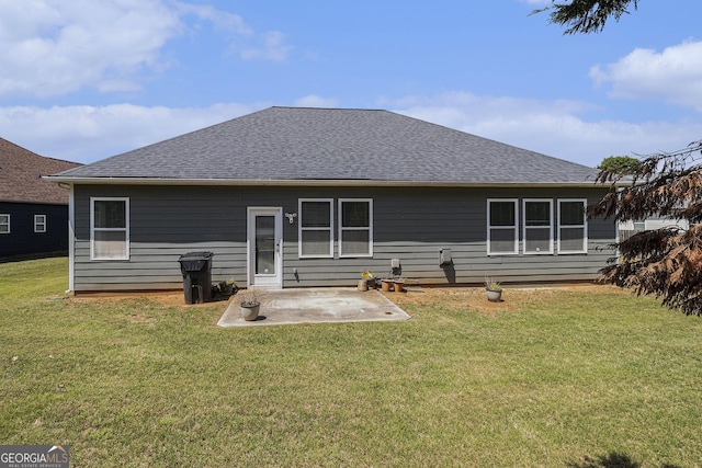 back of house with roof with shingles, a patio area, and a yard