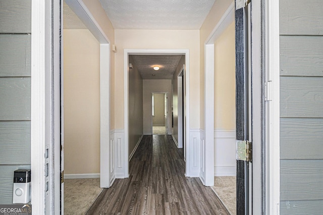 hallway featuring dark wood-type flooring and baseboards