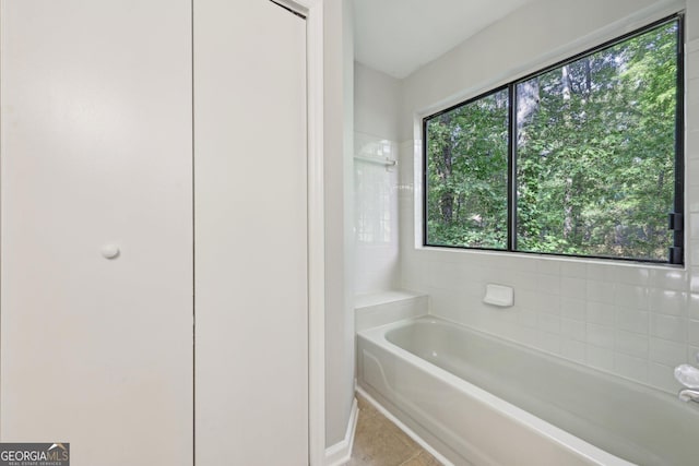 5362 Kelleys Mill Cir, Stone Mountain, GA 30088 - bathroom featuring a tub to relax in, tile patterned flooring, and baseboards