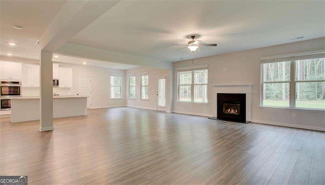 120 Cooper Cv W Lot 60, Fayetteville, GA 30214 - unfurnished living room with a ceiling fan, wood finished floors, a warm lit fireplace, and recessed lighting