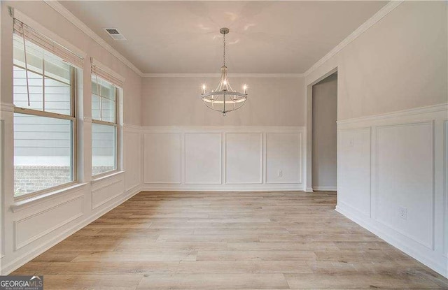 160 Cooper Cv W Lot 64, Fayetteville, GA 30215 - unfurnished dining area featuring a decorative wall, a chandelier, healthy amount of natural light, light wood finished floors, and ornamental molding