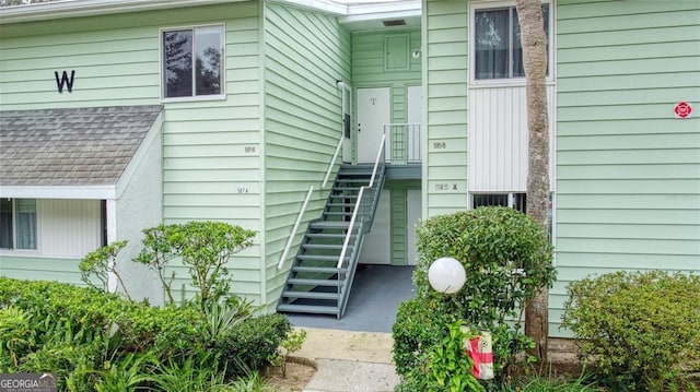 doorway to property with a shingled roof
