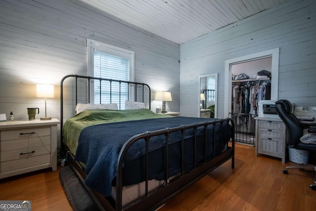 180 Cross St, Maysville, GA 30558 - bedroom with wood walls, a spacious closet, wood finished floors, a closet, and a desk