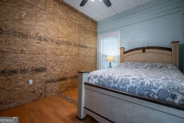 180 Cross St, Maysville, GA 30558 - bedroom with wood finished floors, ceiling fan, and wood walls