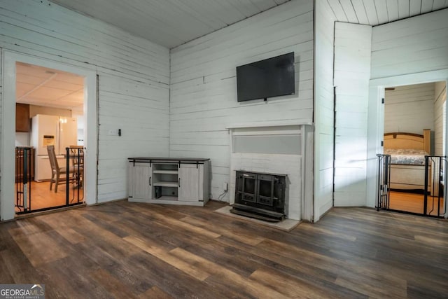 180 Cross St, Maysville, GA 30558 - unfurnished living room with dark wood-style floors, a fireplace, and wooden walls
