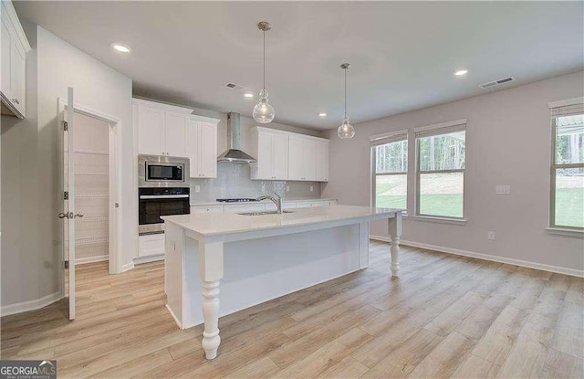 125 Cooper Cv W Lot 72, Fayetteville, GA 30215 - kitchen featuring stainless steel appliances, wall chimney range hood, light countertops, light wood-style flooring, and recessed lighting