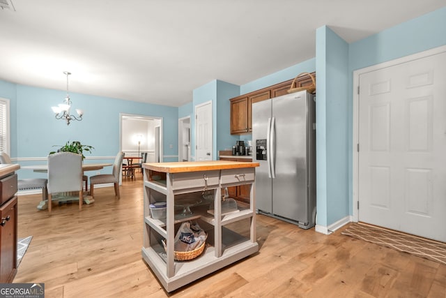 1326 Castleberry Dr, Buford, GA 30518 - kitchen featuring stainless steel fridge, brown cabinets, a chandelier, and light wood-type flooring