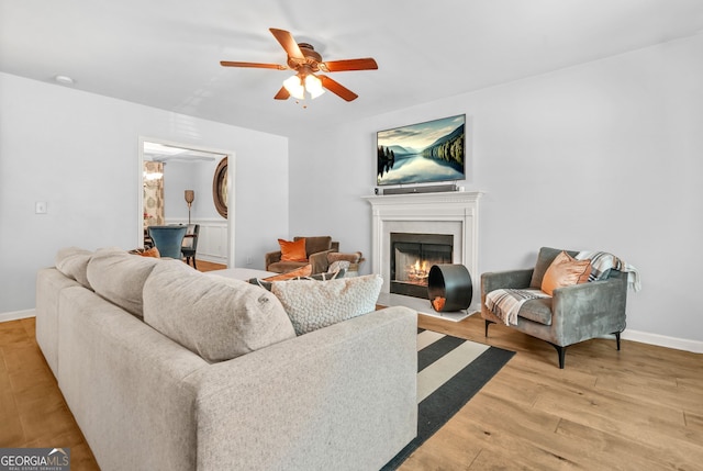 1326 Castleberry Dr, Buford, GA 30518 - living room with a ceiling fan, light wood-type flooring, a fireplace with flush hearth, and baseboards