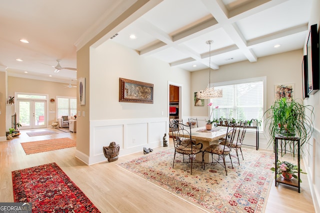 dining space featuring coffered ceiling, beamed ceiling, light wood-style flooring, french doors, and a ceiling fan