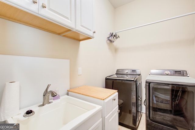 washroom featuring cabinet space, separate washer and dryer, and light wood-style flooring