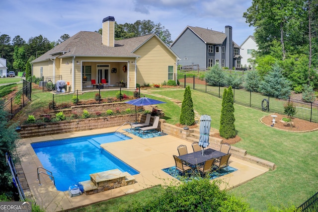 rear view of house featuring a patio area, a chimney, and a shingled roof