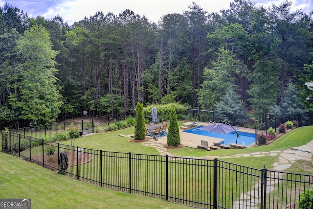 view of community with a pool, a patio area, and a view of trees