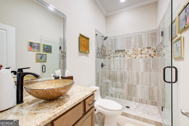 full bath featuring a stall shower, crown molding, vanity, and toilet