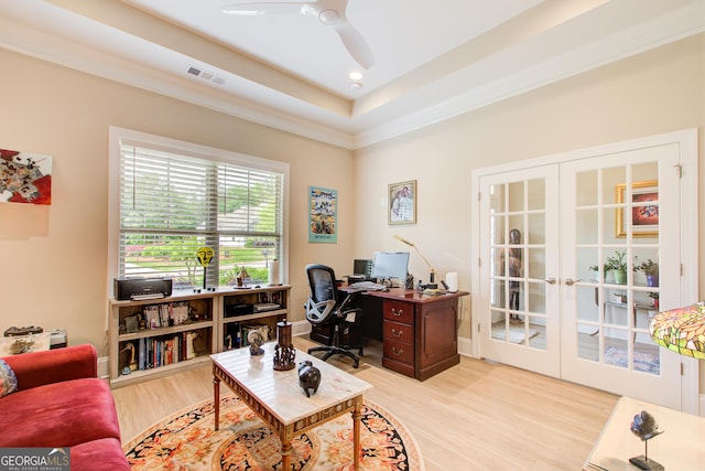 office featuring french doors, light wood-style floors, ceiling fan, and a tray ceiling