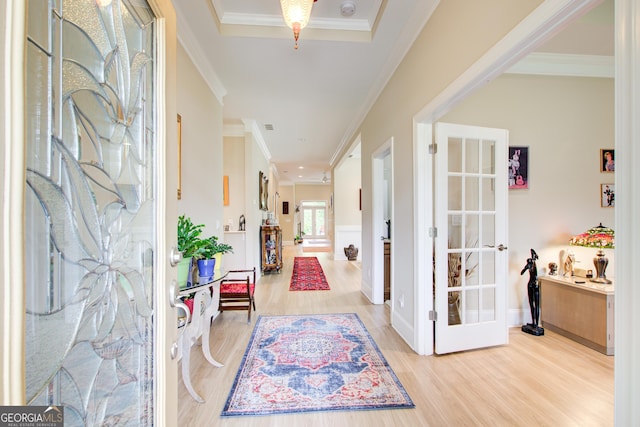 foyer entrance featuring wood finished floors, ornamental molding, baseboards, and french doors