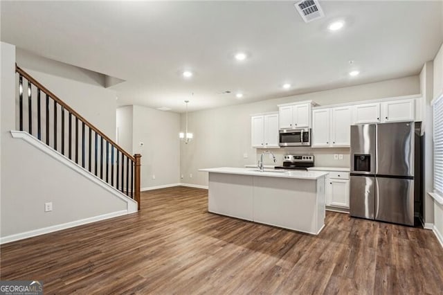 2111 Wesson Ct, Kennesaw, GA 30144 - kitchen with stainless steel appliances, dark wood-style flooring, baseboards, white cabinets, and a center island with sink
