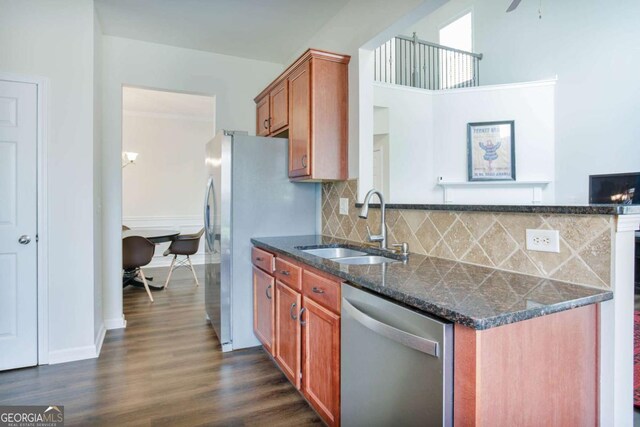 5730 Weddington Dr, Cumming, GA 30040 - kitchen with stainless steel appliances, brown cabinets, dark wood-style flooring, tasteful backsplash, and dark stone counters