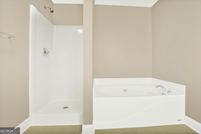 132 Tara Commons Dr, Loganville, GA 30052 - bathroom with a garden tub, baseboards, and a shower