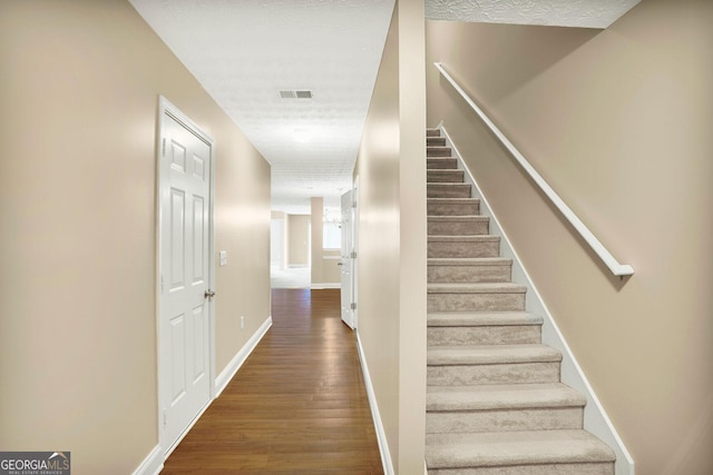132 Tara Commons Dr, Loganville, GA 30052 - staircase featuring wood finished floors, baseboards, and a textured ceiling