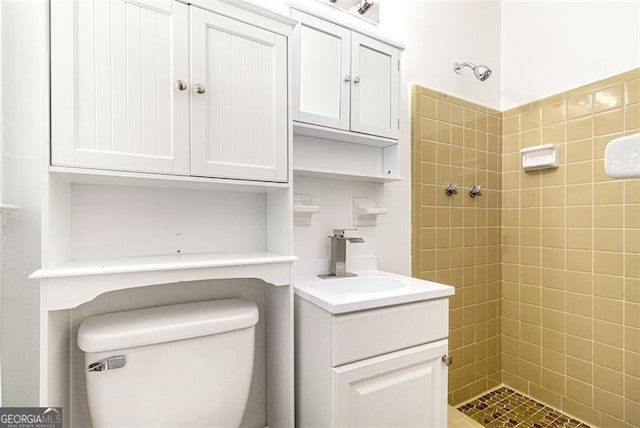 full bath with tiled shower, toilet, and vanity