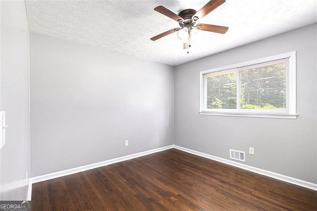 empty room with baseboards, dark wood-style floors, ceiling fan, and a textured ceiling