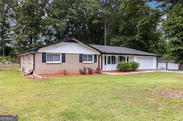 single story home featuring an attached garage, driveway, a front lawn, covered porch, and brick siding