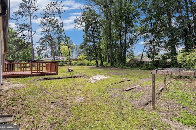 view of grassy yard with a deck