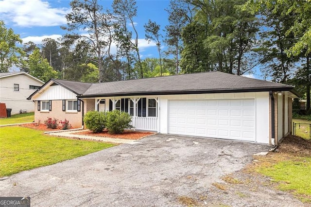 ranch-style house with driveway, a front yard, a garage, and brick siding
