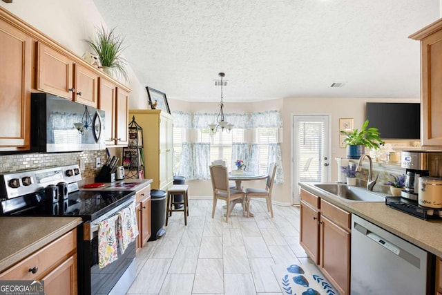 102 Autumn Brooke Trl, Dallas, GA 30157 - kitchen with appliances with stainless steel finishes, a chandelier, tasteful backsplash, hanging light fixtures, and light countertops