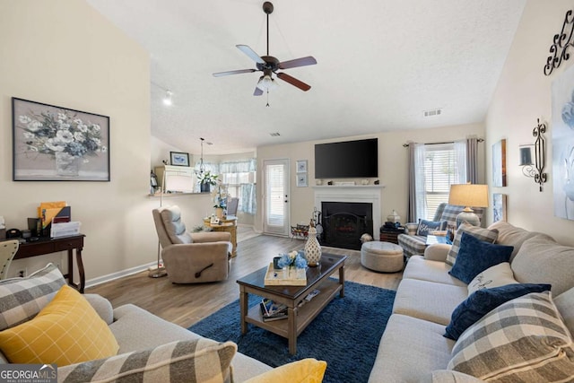 102 Autumn Brooke Trl, Dallas, GA 30157 - living room featuring vaulted ceiling, ceiling fan, wood finished floors, a fireplace, and a textured ceiling