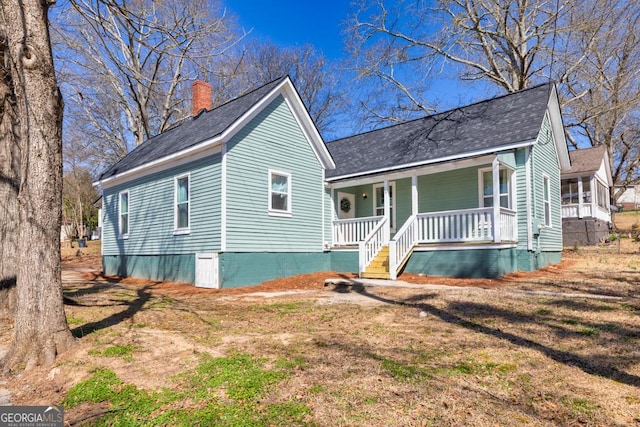 11 Pine St, Covington, GA 30014 - view of front of home with covered porch, a chimney, and a shingled roof