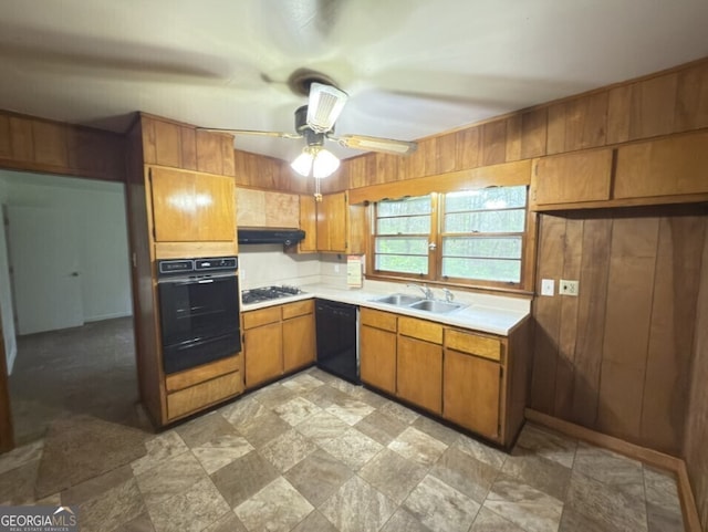 kitchen with black appliances, a sink, a warming drawer, brown cabinets, and light countertops