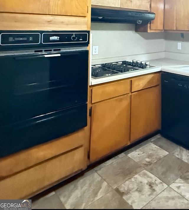 kitchen with under cabinet range hood, black appliances, and light countertops