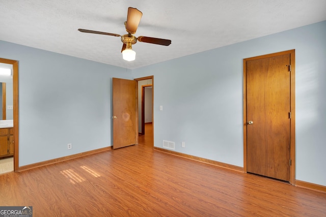 95 Stephens Dr, Covington, GA 30016 - unfurnished bedroom with wood finished floors, baseboards, and ensuite bathroom