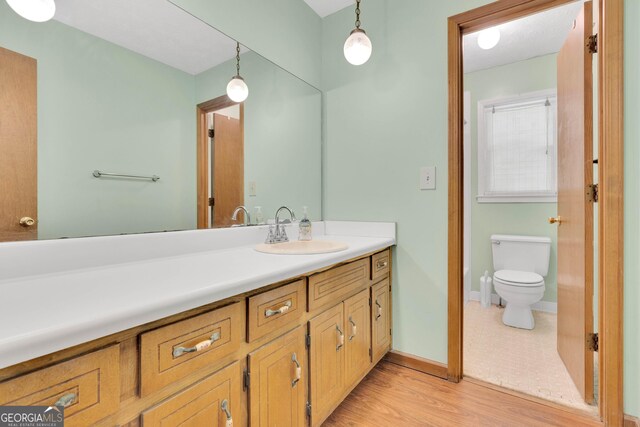95 Stephens Dr, Covington, GA 30016 - bathroom featuring vanity, toilet, wood finished floors, and baseboards