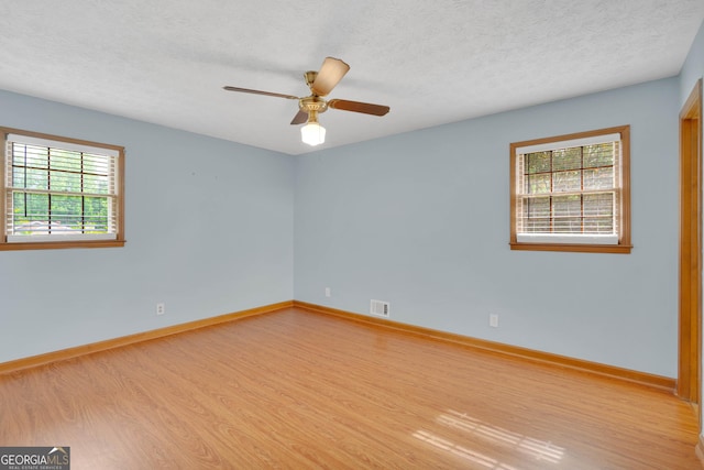 95 Stephens Dr, Covington, GA 30016 - empty room with wood finished floors, healthy amount of natural light, baseboards, and a textured ceiling