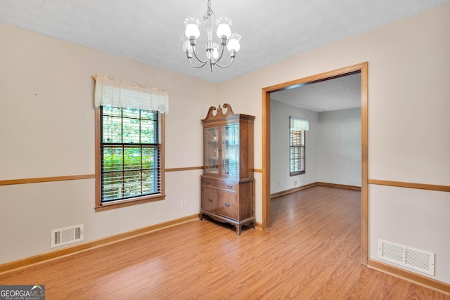 95 Stephens Dr, Covington, GA 30016 - unfurnished room featuring light wood-style flooring, a chandelier, baseboards, and a textured ceiling
